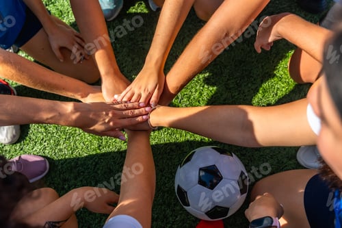 Preview: Soccer team hands joining forming huddle on grass