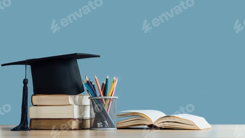 Preview: Graduation day.Mortarboard and graduation scroll on stack of books with pencil color in pencil case