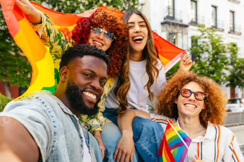 Preview: Multi ethnic friends taking selfie at lgbtqia plus pride parade celebrating with rainbow flag