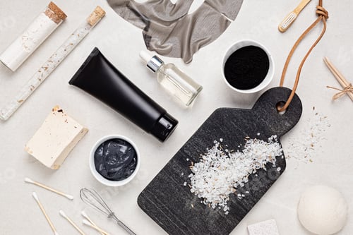 Preview: Flat lay of cosmetic products on the basis of activated charcoal, top view. Beauty and natural skin