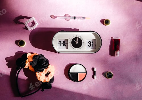 Preview: Alarm clock and Halloween makeup set on a pink background.