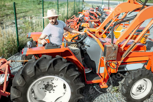 Preview: Agronomist choosing tractor at the agricultural shop