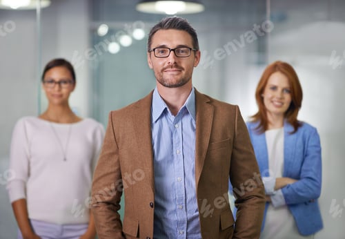 Preview: T.E.A.M. - Together Everyone Achieves More. Portrait of a businessman standing with his colleagues.