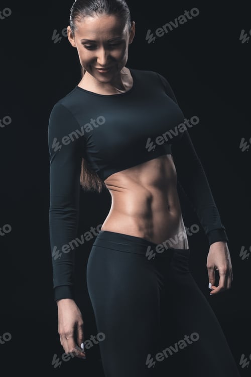 Preview: young fitness woman smiling and posing isolated on black