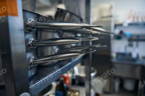 Preview: Shiny, polished frying pans on kitchen racks