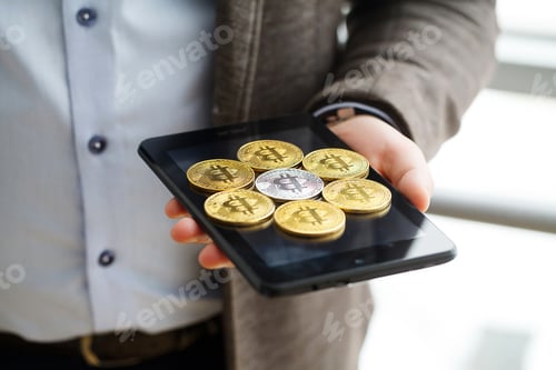 Preview: Hand holding smart phone with bitcoin concept on screen.