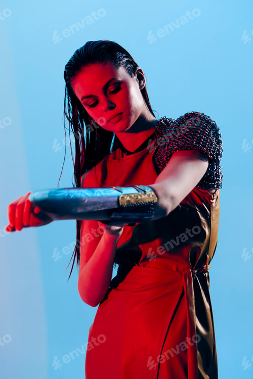 Preview: photo pretty woman Glamor posing red light metal armor on hand isolated background