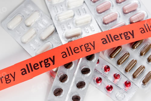Preview: Top view of ribbon with allergy lettering near pills on table