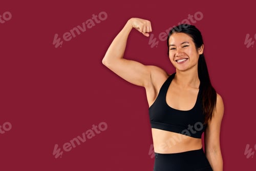 Preview: Portrait of an Asian muscular woman, standing in front of the red wall.