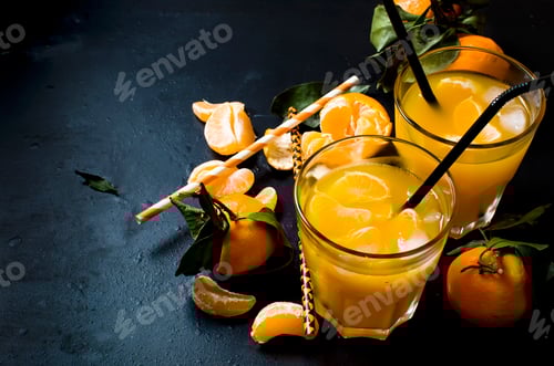 Preview: refreshing cocktail with tangerine, juice and ice in glasses on black background, alcoholic drink