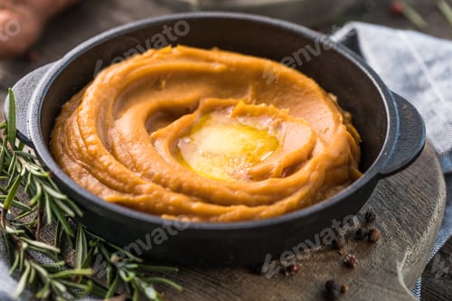 Preview: Spicy mashed sweet potato or sweet potato puree with rosemary in a saucepan on a table
