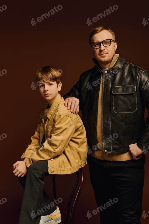 Preview: Father and son share a joyful moment in stylish casual attire in a studio setting
