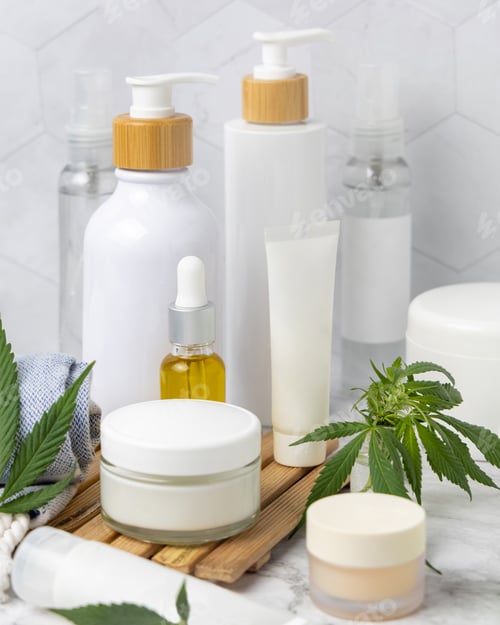 Preview: Blank cosmetic jars, tubes and bottles near green cannabis leaves close up, CBD cosmetic mockup