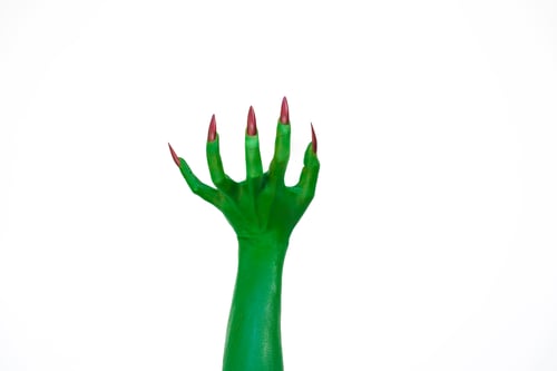 Preview: A green monster hand with long nails, isolated against a dark background, evokes horror and fear