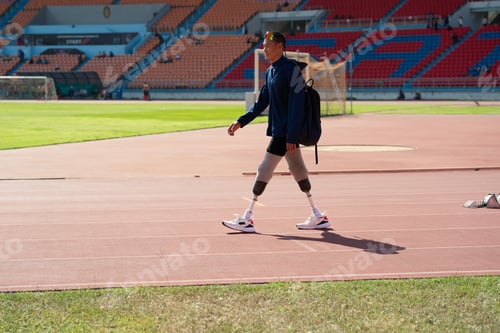 Preview: Asian para-athletes with prosthetic blades sprint on a running track at stadium.