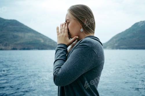 Preview: Young sad Crying woman near the sea with the horizon in the background