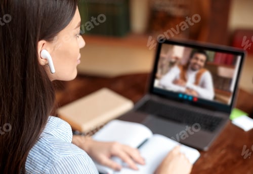 Preview: Woman with earbuds having video conference with teacher