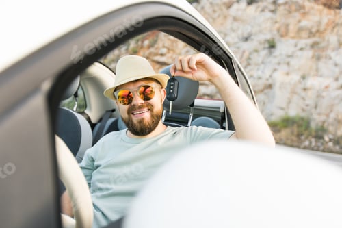 Preview: Handsome happy man showing key of new car - Rental and buy new car concept
