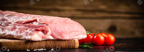 Preview: Raw pork on a cutting board with fresh tomatoes.