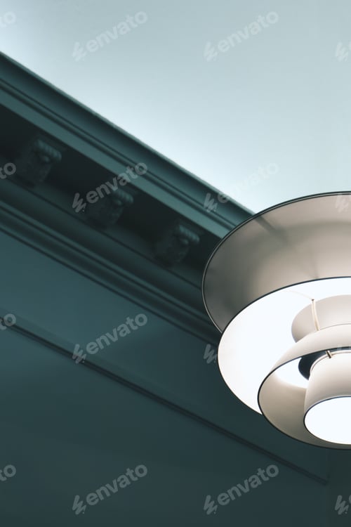 Preview: Vertical low angle shot of a pendant lamp with a vintage wall in the background