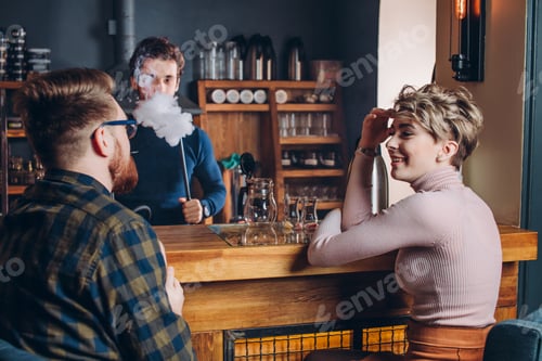 Preview: cheerful young men and woman talking at bar table