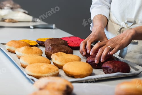 Preview: Crop cook putting sponge cakes on tray in kitchen