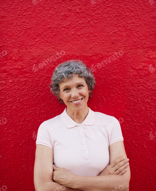 Preview: Smiling Woman with Curly Hair in Front of Wall