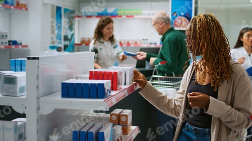 Preview: Young adult looking at boxes of medicaments to cure disease