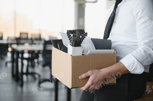 Preview: Close-up Of A Businessperson Carrying Cardboard Box During Office Meeting