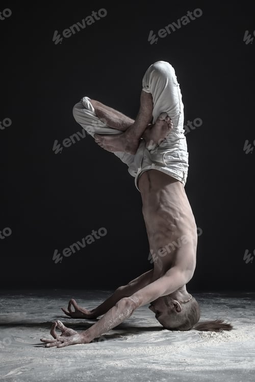 Preview: Flexible yoga man standing in yoga shirshasana headstand pose.