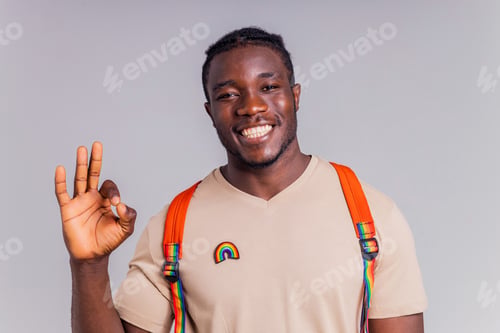 Preview: african american man student with backpack in studio smiling at the camera with a white smile