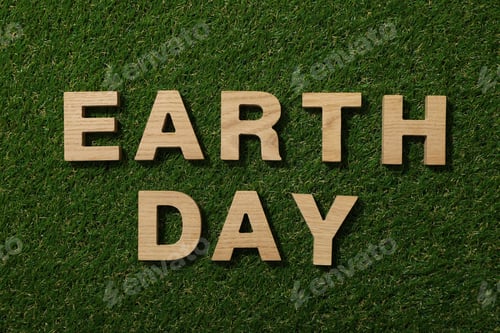 Preview: The inscription Earth Day in wooden letters on the grass