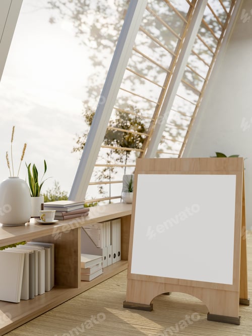 Preview: Blank signboard on wooden floor with bookshelf and sloped roof windows in a bright sunlit attic room