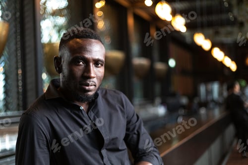 Preview: Portrait of African man standing at bar restaurant