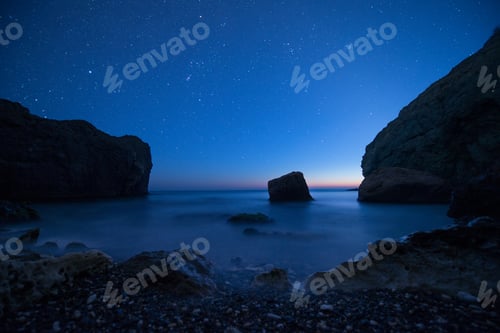Preview: Scenic rocky seashore at sunset under the stars
