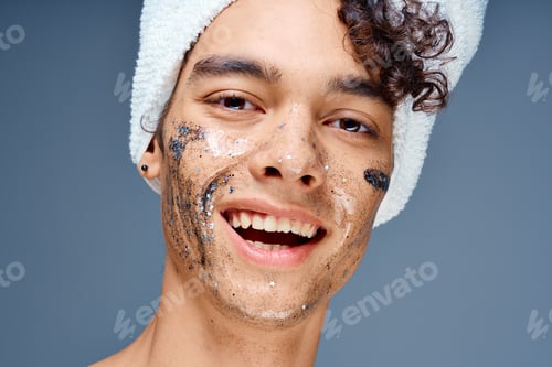 Preview: Cheerful guy with a towel on his head cosmetics on the face clean skin