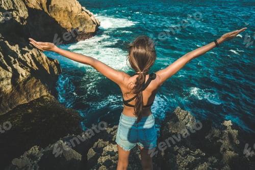 Preview: Young girl with arms raised up. Nusa Penida island