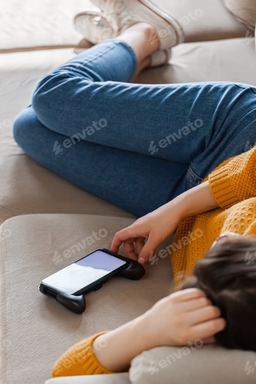 Preview: Young woman sleep on sofa using mobile phone