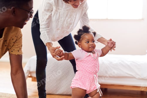 Preview: Parents At Home Encouraging Baby Daughter To Take First Steps