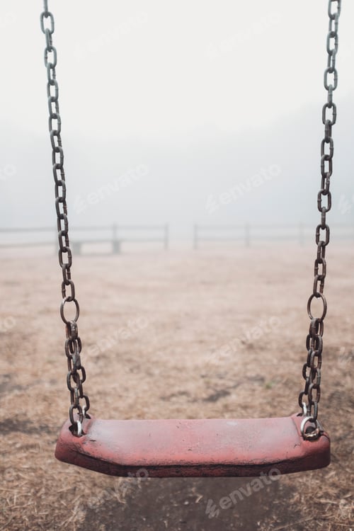 Preview: Ukrainian people against war. Scary empty swing at the park with fog in background.