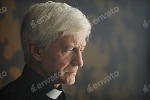 Preview: Close up white haired senior man in clerical collar with serene lighting