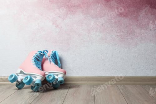 Preview: Vintage roller skates on floor near color wall. Space for text
