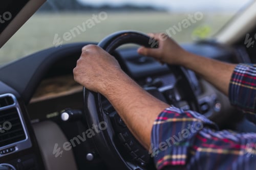 Preview: Closeup shot of the hands of a person on a steering wheel of a modern car