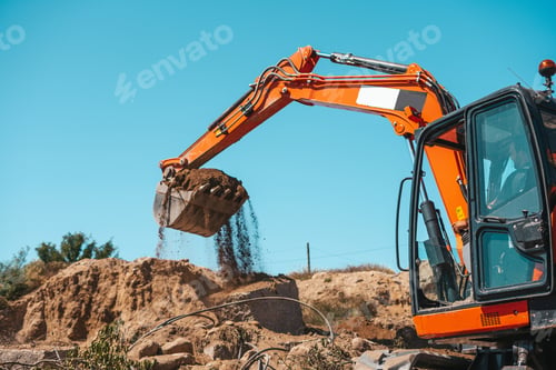 Preview: Closeup of a backhoe with dirt against sky