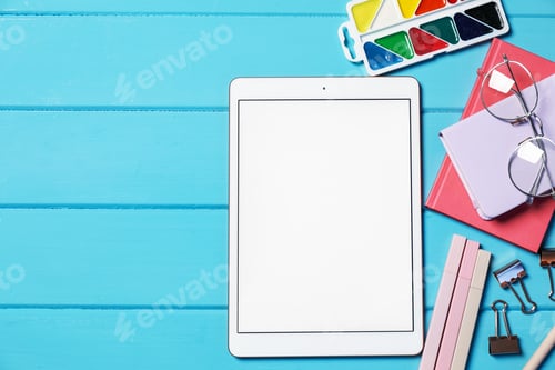 Preview: Tablet, different stationery and glasses on light blue wooden table, flat lay. Space for text