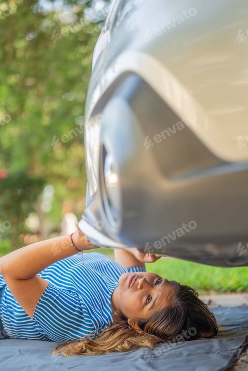 Preview: Woman looking under her vehicle