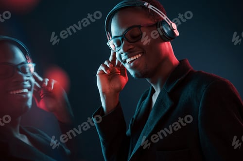 Preview: In glasses. Futuristic neon lighting. Young african american man in the studio