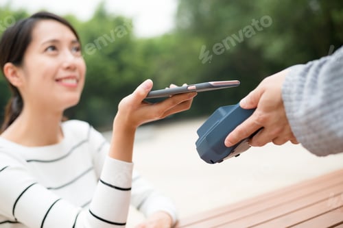 Preview: Woman pay with mobile phone by NFC technology