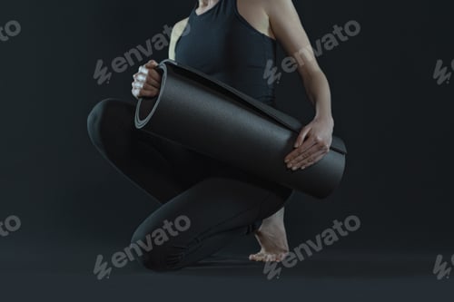 Preview: Young woman practicing yoga positions . sport workout fitness exercise. yoga mat black background.