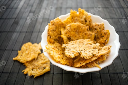 Preview: Cheese Chips Snack in a round white bowl on a black wooden background. Grain Free Dippable Crispy